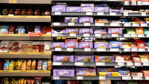 Ein Supermarktregal voller Schokoladentafeln. Auch Milka steht in diesem Regal