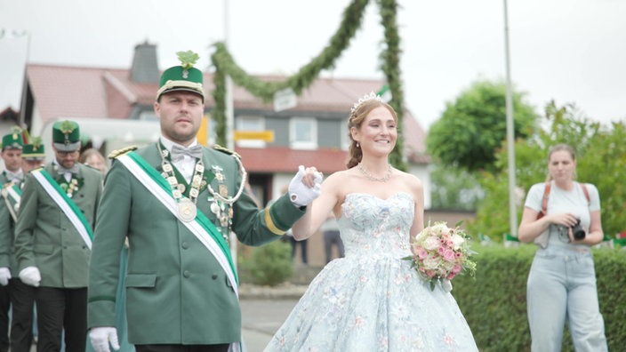 Festumzug. Carolin in ihrem Traumkleid schreitet als Königin durch den Ort