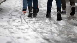 Schulkinder laufen durch halb getauten matschigen Schnee