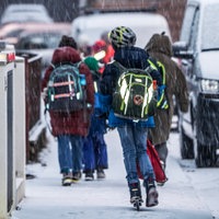 Grundschüler laufen über schneebedeckte Gehwege