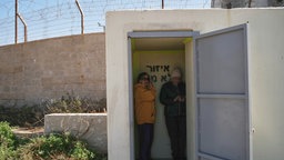 Zwei Frauen stehen in einem Schutzraum in Haifa und schützen sich vor Gegenangriffen des Irans