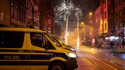 Polizeiwagen mit Feuerwerk im Hintergrund