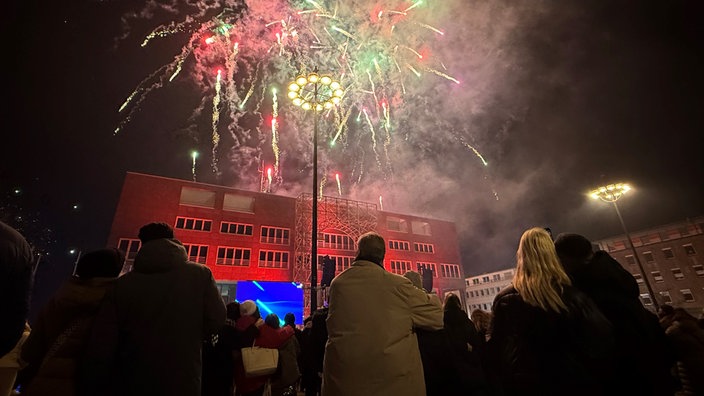 Menschen schauen sich Silvesterfeuerwerk im Ruhrgebiet an.