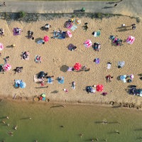 Viele Badegäste liegen auf den Liegeflächen am Rather See