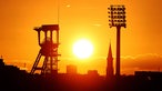 Die Sonne geht über dem Förderturm der Zeche Holland und einem Flutlichtmast des Lohrheidestadion auf