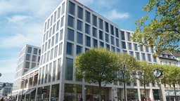 Das Gebäude der Stadtsparkasse KölnBonn am Friedensplatz von außen - ein graues Hochhaus mit hohen Fenstern