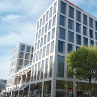 Das Gebäude der Stadtsparkasse KölnBonn am Friedensplatz von außen - ein graues Hochhaus mit hohen Fenstern