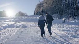 Zwei Spaziergänger auf einer Piste