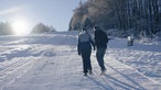 Zwei Spaziergänger auf einer Piste
