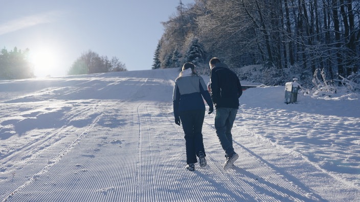 Zwei Spaziergänger auf einer Piste