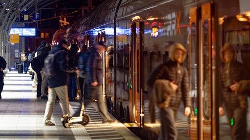Passagiere steigen in einen Regionalzug ein