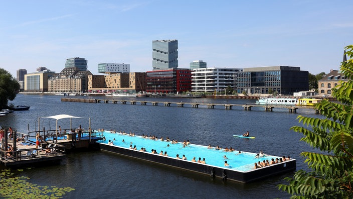 Auf der Spree in Berlin baden Menschen in einem großen mit Wasser gefüllten Schiff