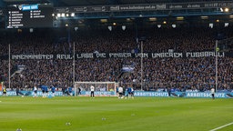 Fans von Bielefeld zeigen ein Transparent, das den NRW-Innenminister Reul anspricht