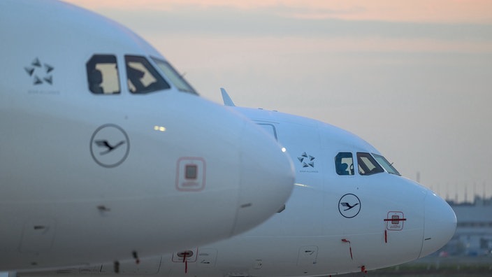 Zwei Flugzeuge stehen auf der Rollbahn eines Flughafens