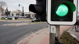 Eine Kreuzung. Im Vordergrund eine grüngeschaltete Ampel