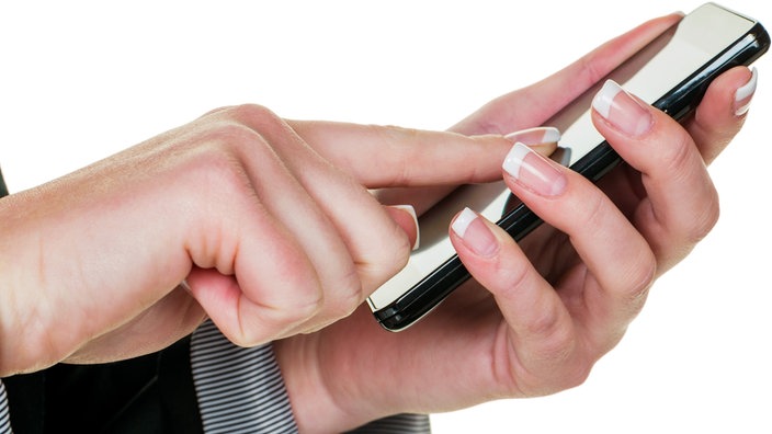 Auf einem Mobiltelefon wird eine SMS geschrieben