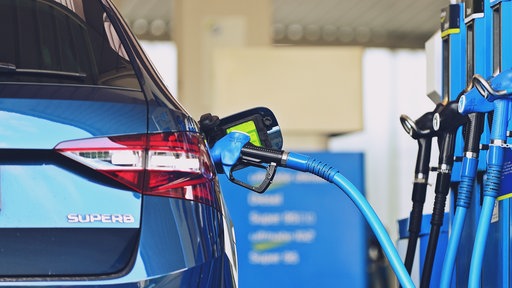 Auto steht an einer Zapfsäule an einer Tankstelle 