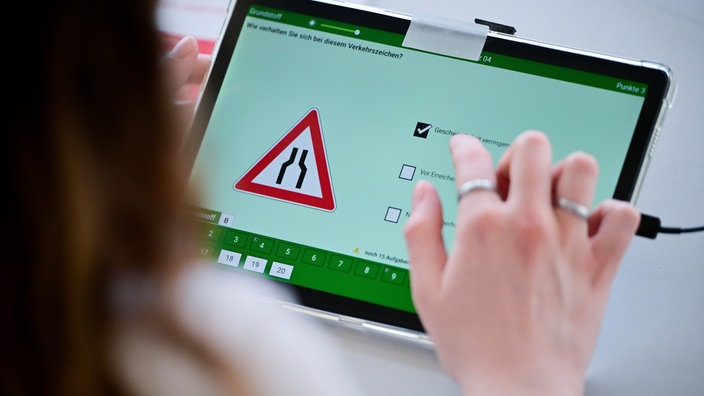 Eine Frau beantwortet eine Frage der theoretischen Prüfung des Führerscheins.