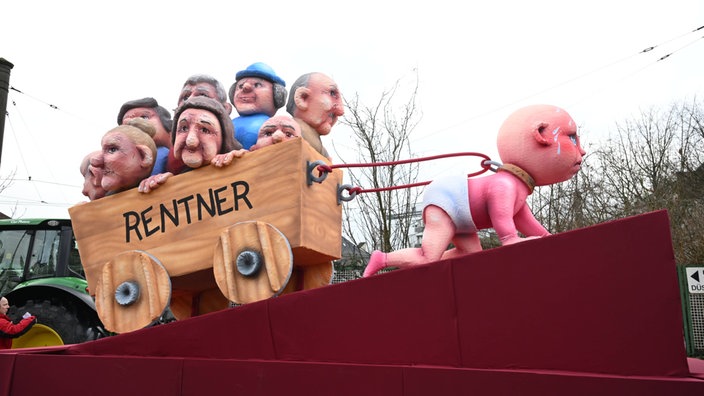 Ein Wagen auf dem ein Baby mit einem Halsband Rendner in einem Wagen zieht 