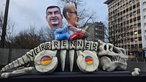 Markus Söder und Friedrich Merz auf einem beinlosen Skelett mit der Aufschrift "Verbrenner"