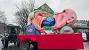 Donald Trump und Wladimir Putin essen ein blaues Schwein mit der Aufschrift "Europa"