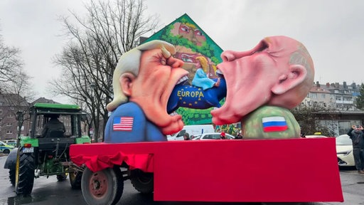 Donald Trump und Wladimir Putin essen ein blaues Schwein mit der Aufschrift "Europa"