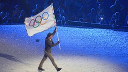 US-Schauspieler Tom Cruise hält während der Schlussfeier die olympische Fahne