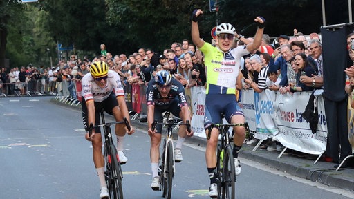 Ein Radprofi jubelt nach dem Zielsprint bei der Tour de Neuss 2024