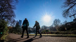 Zwei Personen spazieren durch einen Park