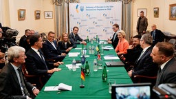 Politiker, darunter der ukrainische Präsident Selenskyj, sitzen um einen langen Tisch
