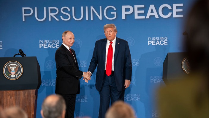Präsident Trump und Präsident Putin schütteln Hände bei der Pressekonferenz in Alaska 