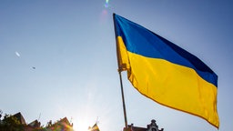 Eine Person hält eine Ukraineflagge