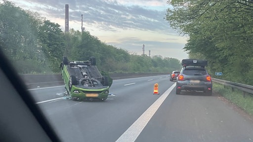 Ein Auto liegt nach einem Unfall auf dem Dach.