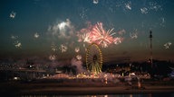 Feuerwerkskörper werden vom Rheinufer in den Himmel geschossen