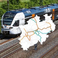 Karte des Schienennahverkehrs in NRW vor einem fahrenden Zug 