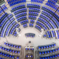 Blick von oben auf die blauen Sitze im leeren Plenarsaal des Bundestags