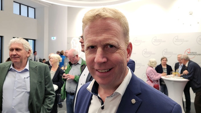 Henning Rehbaum schaut lächelnd in die Kamera 