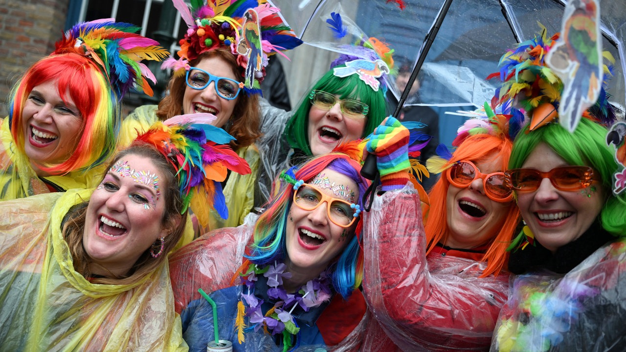 Karnevalisten bei Regen vor dem Rathaus in Düsseldorf