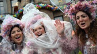 Jeckinnen stehen vor dem Rathaus in Düsseldorf im Regen