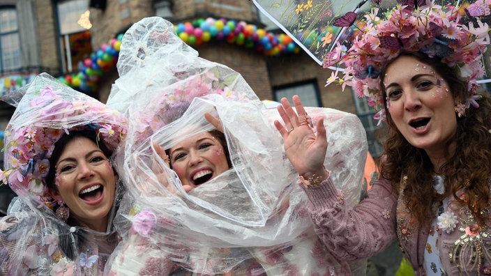 Jeckinnen stehen vor dem Rathaus in Düsseldorf im Regen