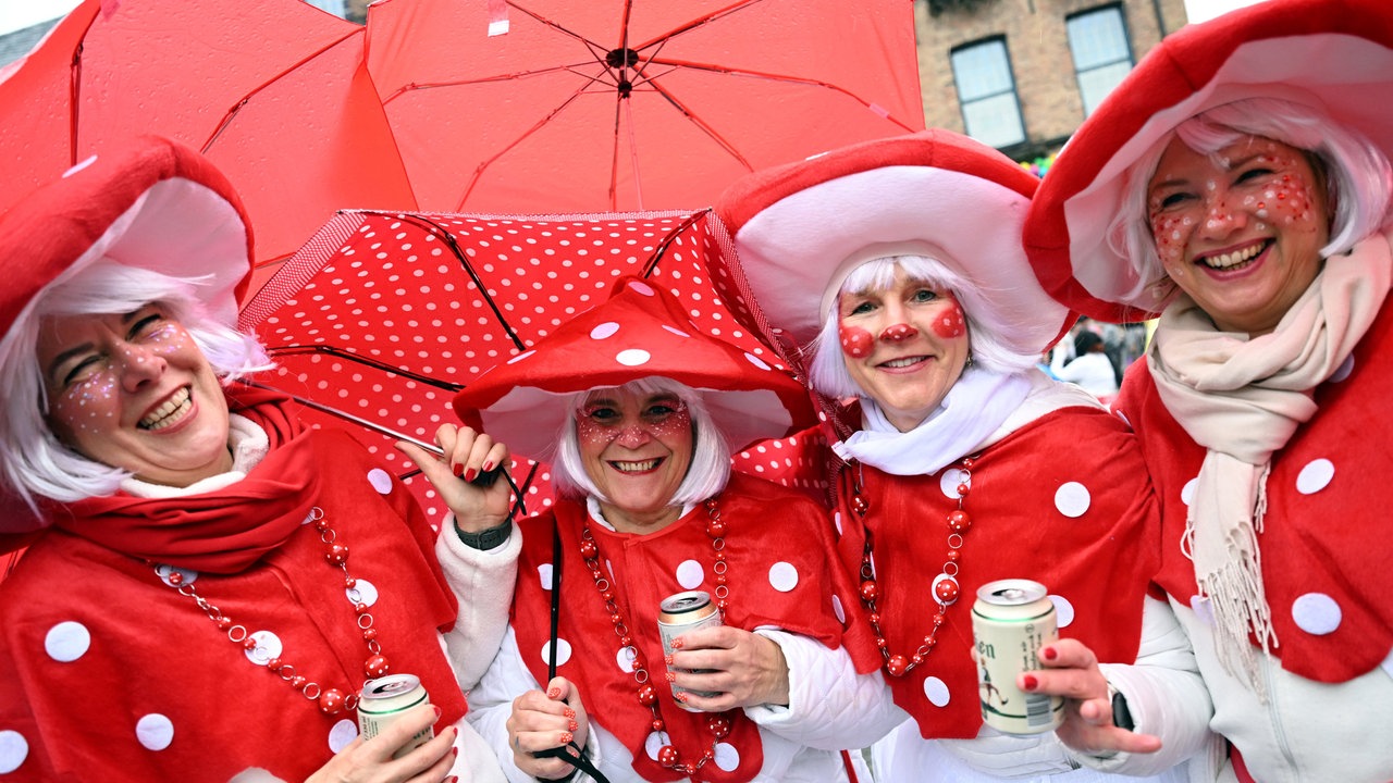 Jeckinnen stehen vor dem Rathaus in Düsseldorf im Regen
