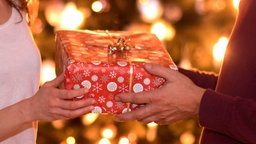 Zwei Personen übergeben sich ein Geschenk