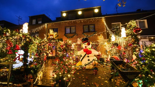 Ein Reihenhaus mit einer großen Menge an Weihnachtsdekoration und Weihnachtsbeleuchtung