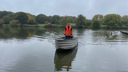Ein Mann steht in einem Boot auf einem See