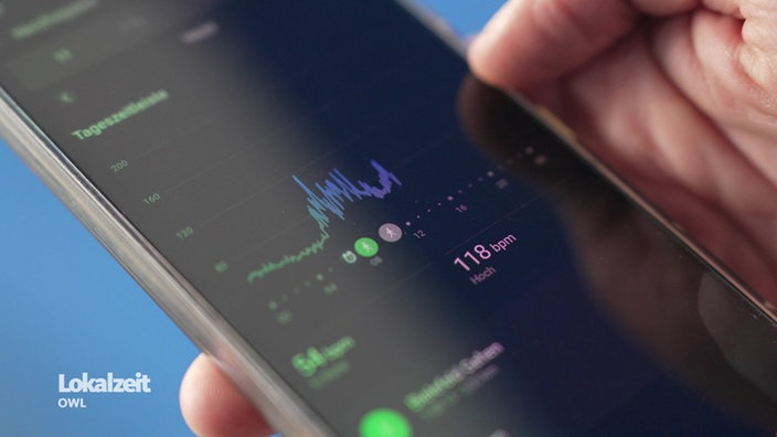 Auf einem Handydisplay wird ein Puls von 118bpm angezeigt.