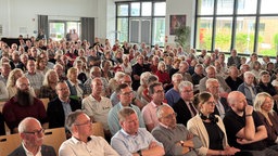 Ein Publikum das aud Stühlen sitzt