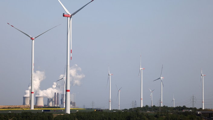 Windräder von RWE drehen sich am Tagebau Garzweiler vor dem Braunkohlekraftwerk Neurath.