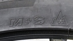 An einem Winterreifen sind die Buchstaben M+S (Matsch und Schnee)und das Schneeflockensymbol zu sehen