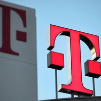 Logo der Deutschen Telekom, pinkes "T" mit drei pinken Punkten daneben, im Hintergrund pinkes "T" auf weißem Untergrund