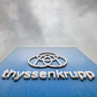 Dunkle Wolken über einem Firmenlogo von Thyssenkrupp in Duisburg.